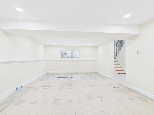 below grade area featuring baseboards, recessed lighting, and stairs