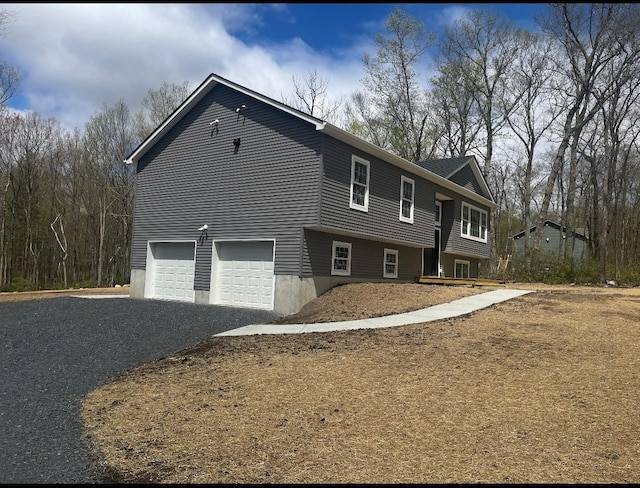 view of front of property with gravel driveway and an attached garage