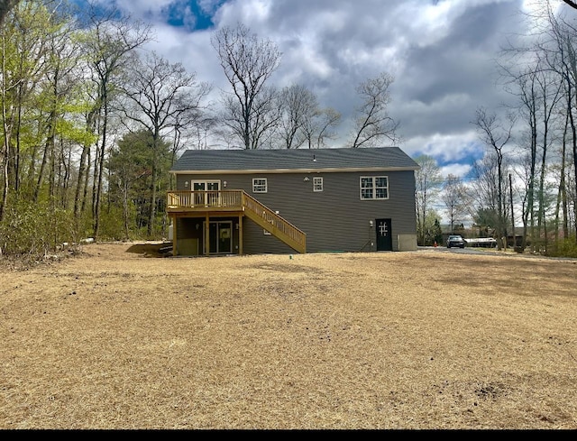 back of house featuring stairway and a deck