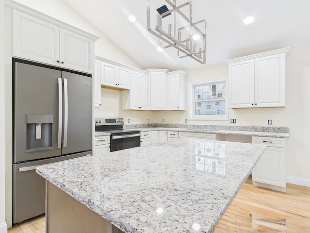 kitchen with light stone countertops, stainless steel appliances, white cabinets, a notable chandelier, and lofted ceiling