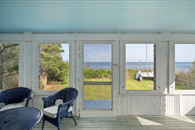 sunroom / solarium featuring a water view