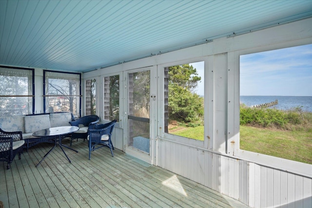 sunroom with a water view, plenty of natural light, and outdoor lounge area