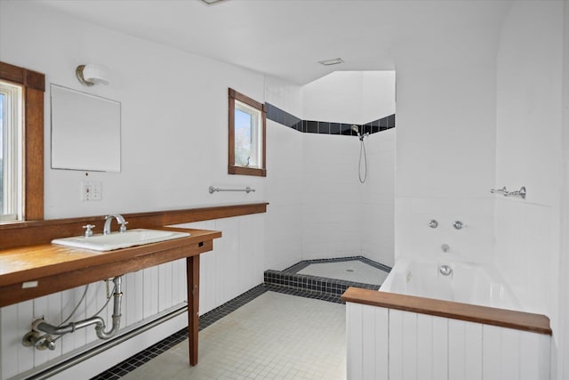 full bathroom with a tile shower, a baseboard radiator, healthy amount of natural light, and a tub