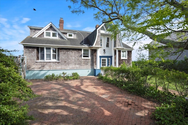 shingle-style home featuring a chimney and a shingled roof