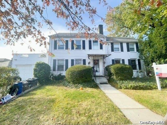 52-06 Bowne St, Flushing, NY 11355 - colonial house with a front lawn, a garage, and a chimney