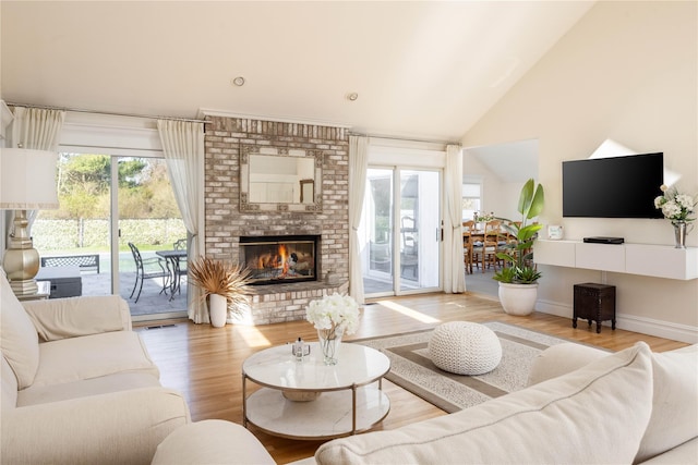 3 Clay Pit Rd, Remsenburg, NY 11960 - living room with a brick fireplace, lofted ceiling, a healthy amount of sunlight, and wood finished floors