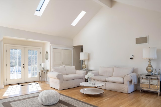 3 Clay Pit Rd, Remsenburg, NY 11960 - living area with high vaulted ceiling, a skylight, light wood-style floors, french doors, and visible vents