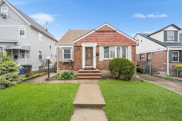 100-16 205th Pl, Hollis, NY 11423 - bungalow with brick siding, a front lawn, fence, and roof with shingles