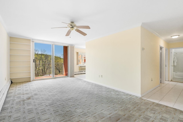 unfurnished room featuring carpet flooring, a ceiling fan, baseboards, ornamental molding, and tile patterned flooring