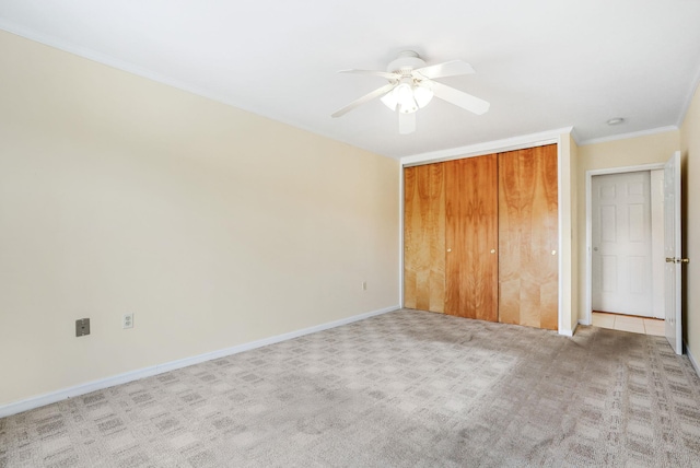 unfurnished bedroom featuring ornamental molding, a ceiling fan, light carpet, and baseboards