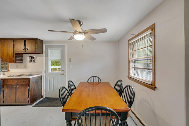 dining area featuring ceiling fan, a wealth of natural light, and marble finish floor