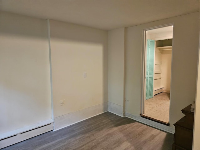 23 Beverly Rd, Glen Cove, NY 11542 - unfurnished room with a baseboard heating unit, dark wood-type flooring, and baseboards