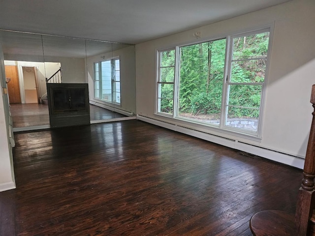 23 Beverly Rd, Glen Cove, NY 11542 - unfurnished living room featuring hardwood / wood-style flooring, a baseboard heating unit, and baseboards