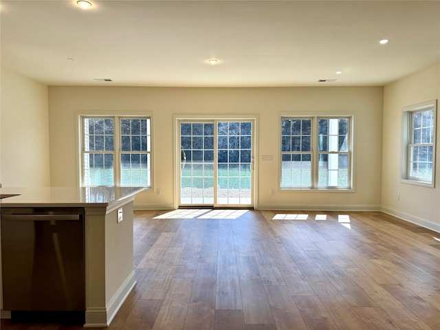 interior space with dishwashing machine, dark wood-type flooring, baseboards, and open floor plan