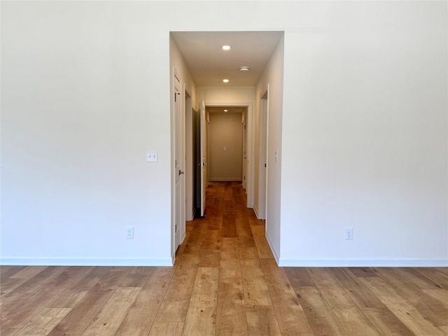hallway with light wood-style flooring, recessed lighting, and baseboards
