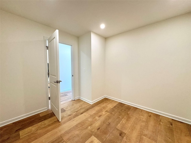unfurnished room featuring baseboards and light wood-style floors