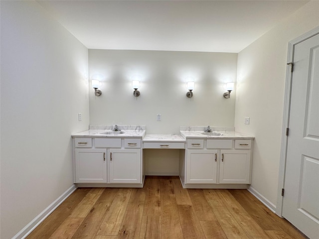 bathroom with baseboards, vanity, and hardwood / wood-style flooring