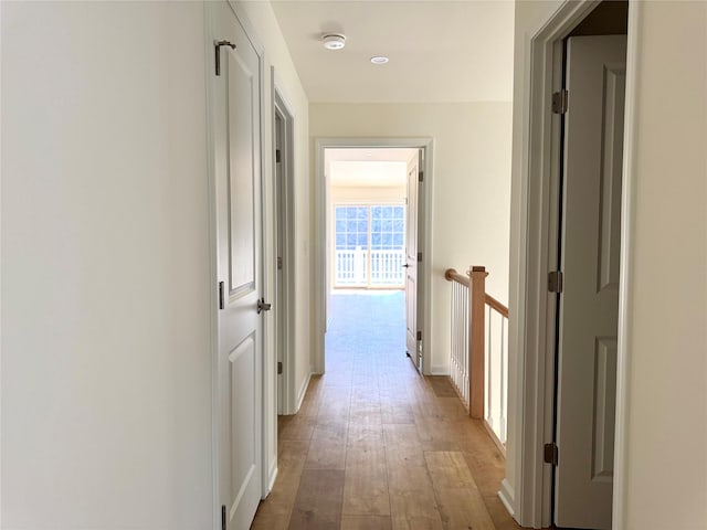hallway featuring baseboards and light wood finished floors