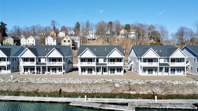 rear view of property featuring a water view, a residential view, and a balcony