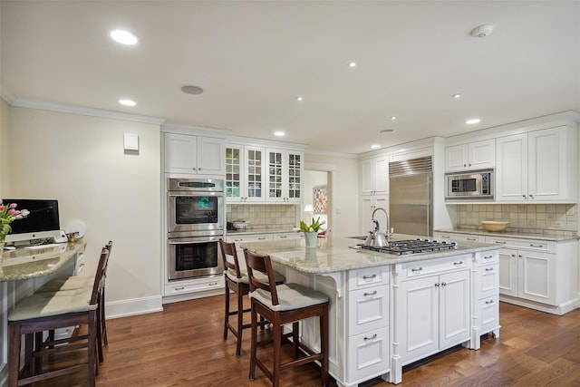 17 Eastwoods Rd, Pound Ridge, NY 10576 - kitchen with built in appliances, ornamental molding, tasteful backsplash, a kitchen bar, and white cabinetry