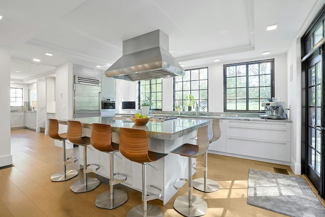 165 Valley Rd, New Rochelle, NY 10804 - kitchen featuring recessed lighting, a kitchen island, island exhaust hood, stainless steel appliances, and a breakfast bar area
