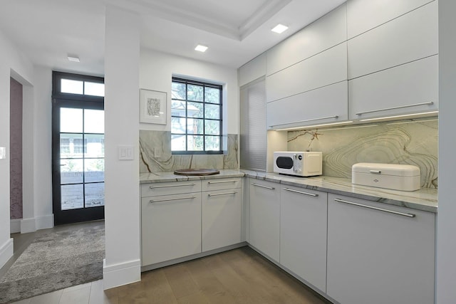 165 Valley Rd, New Rochelle, NY 10804 - kitchen with white cabinets, backsplash, and white microwave