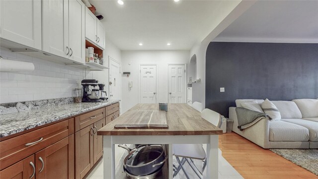 kitchen featuring recessed lighting, arched walkways, backsplash, and wooden counters