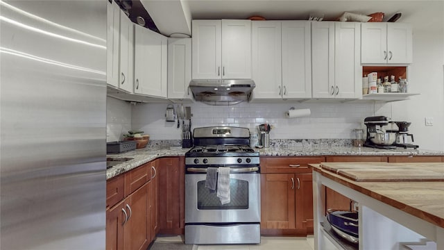 kitchen with stainless steel appliances, under cabinet range hood, white cabinetry, and tasteful backsplash