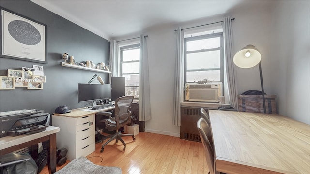 office featuring light wood-type flooring, radiator heating unit, and cooling unit