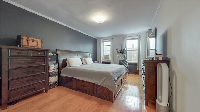 bedroom featuring light wood-type flooring and crown molding