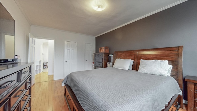 bedroom with light wood-style floors and ornamental molding