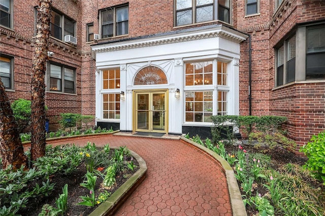 property entrance featuring brick siding and cooling unit