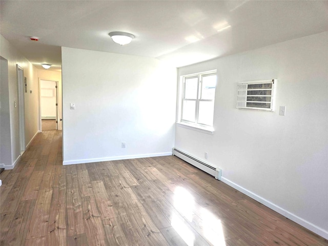 134-15 160th St, Jamaica, NY 11434 - unfurnished room with a baseboard radiator, wood finished floors, baseboards, a wall mounted air conditioner, and a baseboard heating unit