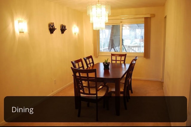 carpeted dining space with a notable chandelier and baseboards
