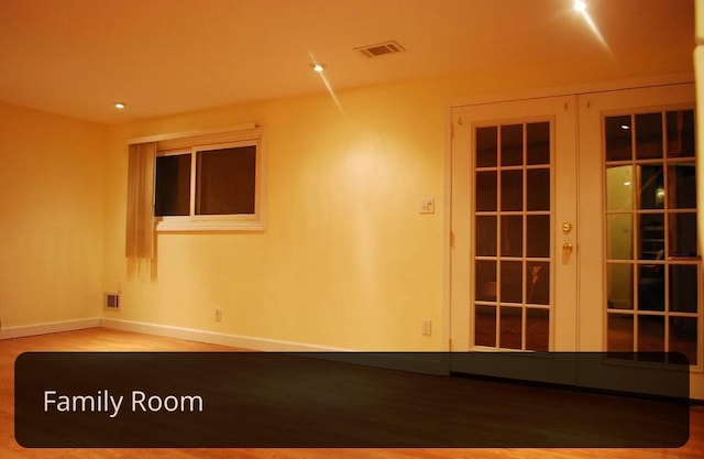 unfurnished room with french doors, wood finished floors, baseboards, and visible vents