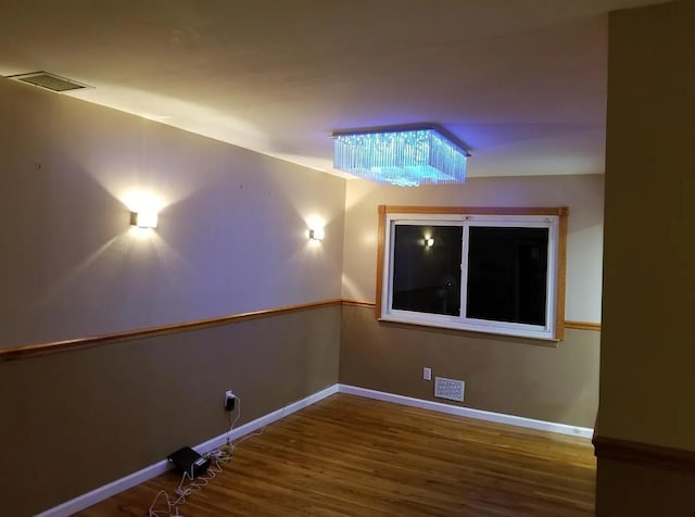 home theater room with visible vents, baseboards, and wood finished floors