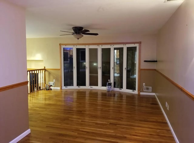 unfurnished room featuring visible vents, ceiling fan, wood finished floors, and baseboards