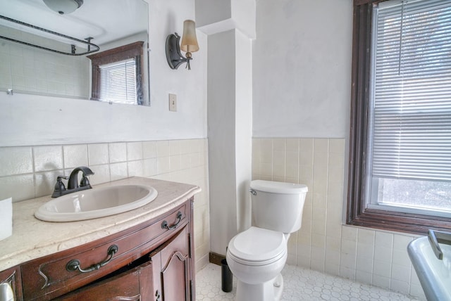 58 Summitville Rd, Wurtsboro, NY 12790 - bathroom with wainscoting, tile walls, toilet, and a healthy amount of sunlight