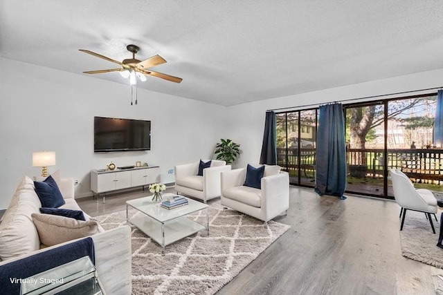 living room with baseboards, a ceiling fan, and wood finished floors