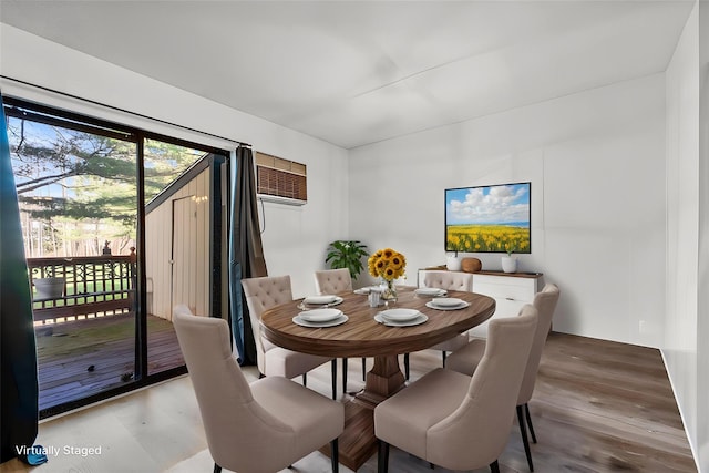 dining area featuring wood finished floors and a wall unit AC