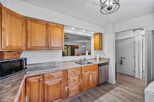 kitchen featuring a sink, light wood-type flooring, dishwasher, and brown cabinets