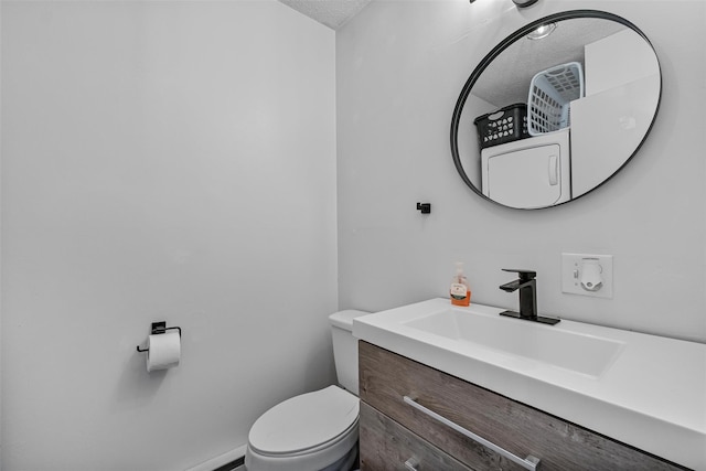 bathroom featuring toilet, a textured ceiling, and vanity