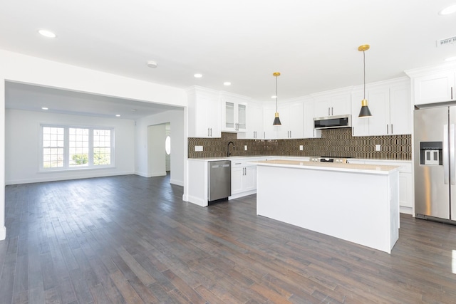 38 Melody Ln, Amityville, NY 11701 - kitchen featuring tasteful backsplash, open floor plan, white cabinetry, appliances with stainless steel finishes, and a sink