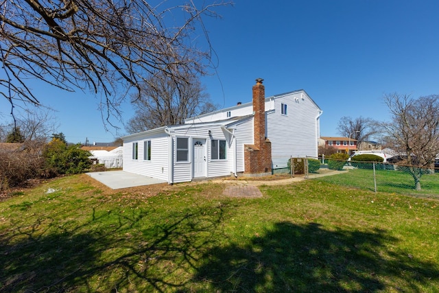 38 Melody Ln, Amityville, NY 11701 - back of property featuring a patio area, a chimney, fence, and a lawn
