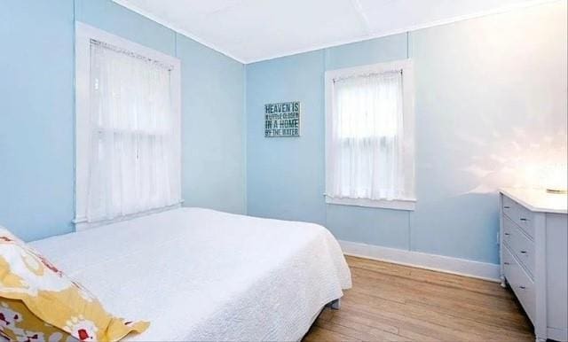 bedroom with baseboards and wood finished floors