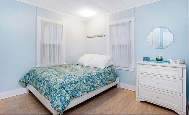 bedroom with baseboards and light wood-type flooring