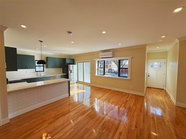 kitchen featuring ornamental molding, light countertops, an AC wall unit, and appliances with stainless steel finishes