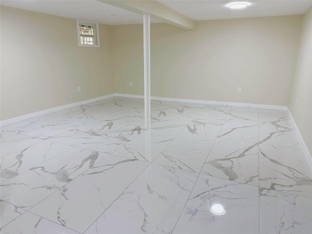 below grade area featuring baseboards and marble finish floor