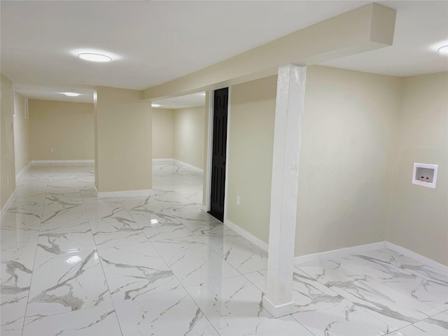 finished basement with baseboards and marble finish floor
