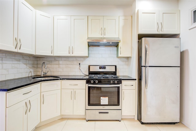 kitchen with light tile patterned floors, a sink, appliances with stainless steel finishes, under cabinet range hood, and backsplash